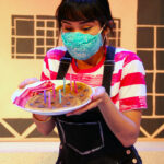 Carmela enjoys a special plate of pancakes on her birthday. Mireya Luna as Carmela in The Rose Theater's production of CARMELA FULL OF WISHES, making its world premiere Jan 28 - Feb 13, 2022.