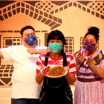 Big Brother (Isaiah Ruiz) and Mami (Tatiana Sandoval) present Carmela (Mireya Luna) with birthday pancakes in The Rose Theater's production of CARMELA FULL OF WISHES, making its world premiere Jan 28 - Feb 13, 2022.